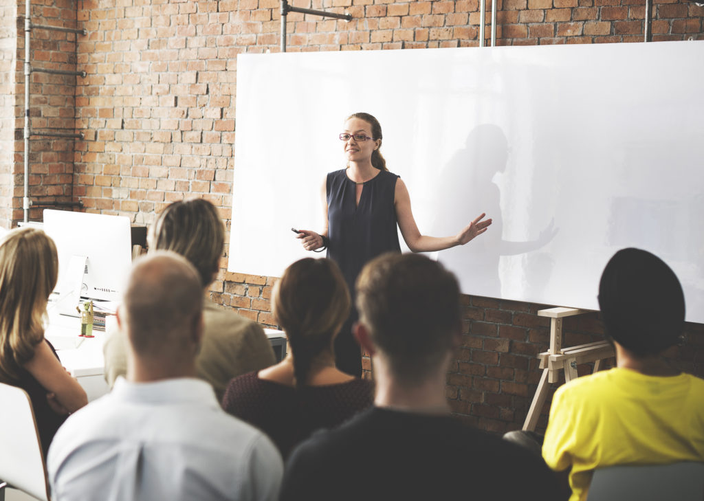 Woman giving a business training in front of a group of people